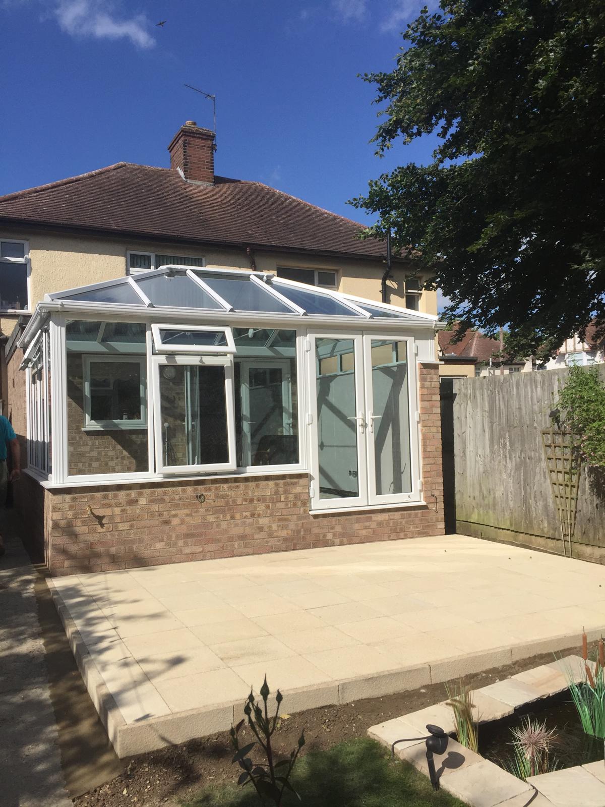 White conservatory in summer light by Advanced Builders
